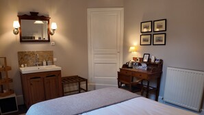 A bedroom with a bed, a dresser, a vanity with a mirror, and a desk with a chair. - Comfortabele en charmante kamer Montravel in de nummer 1 B&B van Ribérac. (Ribérac)