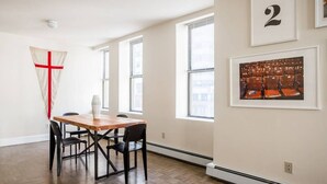 A room with a wooden dining table, black chairs, a large window, and a framed picture on the wall. - New to VRBO!  Awesome location downtown, closeby bars, restaurants + historic sites Walk Anywhere! (Boston)