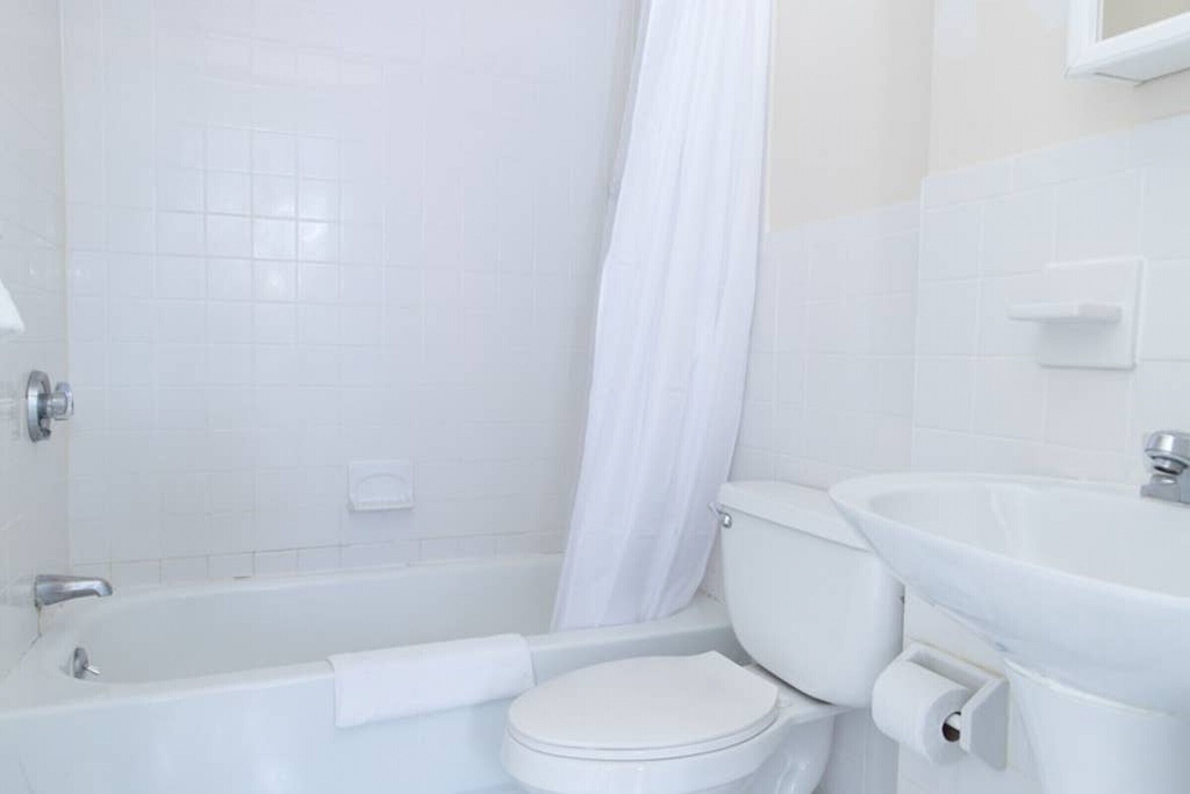 A bathroom with a bathtub, toilet, and sink.