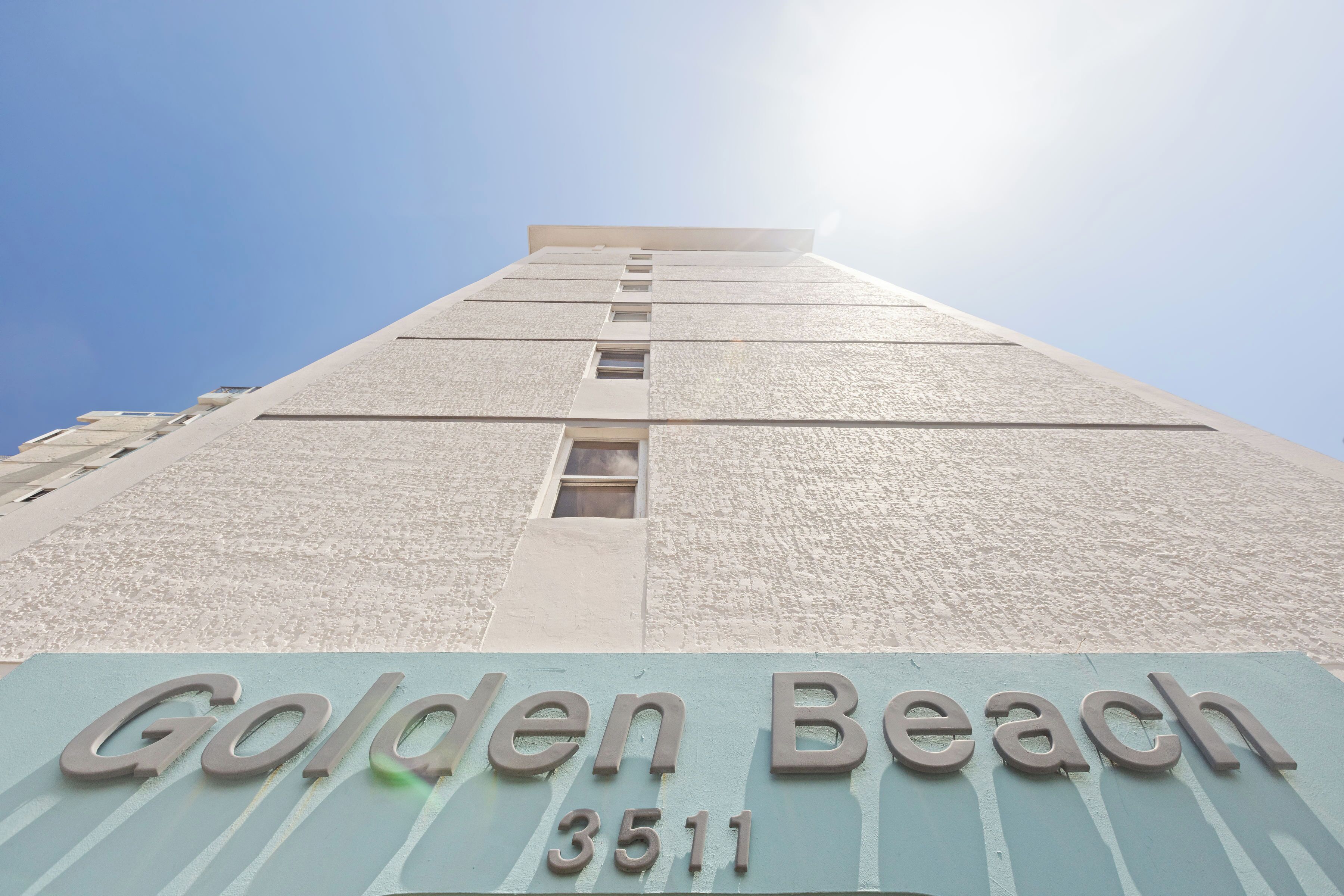A building with the sign "Golden Beach 3511" indicating its address.
