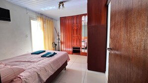 A bedroom with a bed, a wardrobe, and a door leading to another room. - Casa com Piscina, Churrasqueira e Mesa de Bilhar (Caxias do Sul)