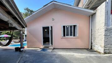 A single-story building with a pink exterior, a door, and a window.