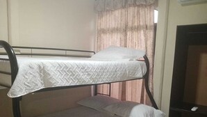 A bunk bed with white bedding in a room with a tiled floor, a curtain, and an air conditioning unit. - Casa Vacacional (Ciudad Cortes)