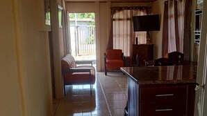 A compact kitchen with a tiled floor, a built-in refrigerator, and a flat-screen TV mounted on the wall. - Casa Vacacional (Ciudad Cortes)