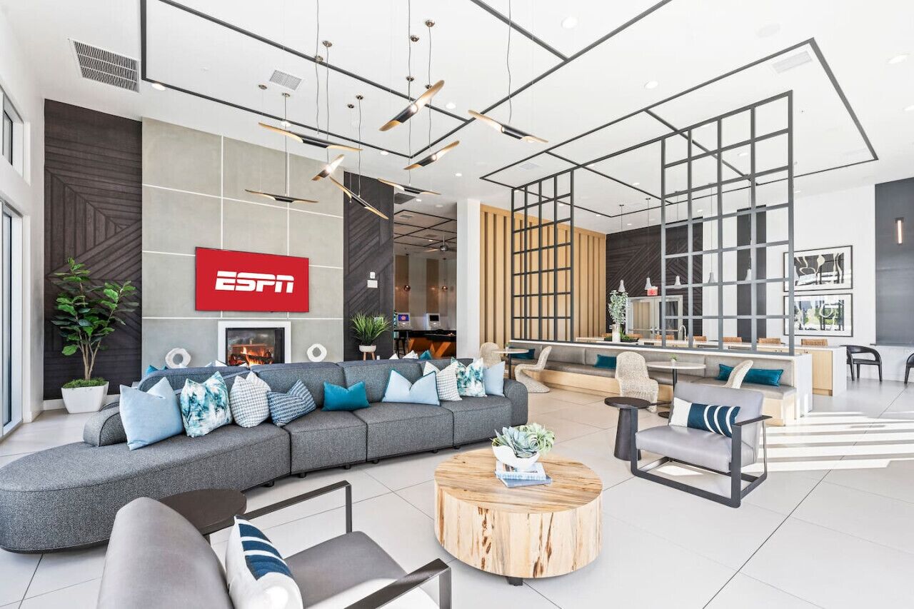 Un espacio de sala moderno con un sofá grande, una mesa de centro y disposición de asientos.