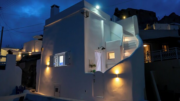 A white building with a staircase, a window, and a door. - Akrotiri Castle View (Santorini)