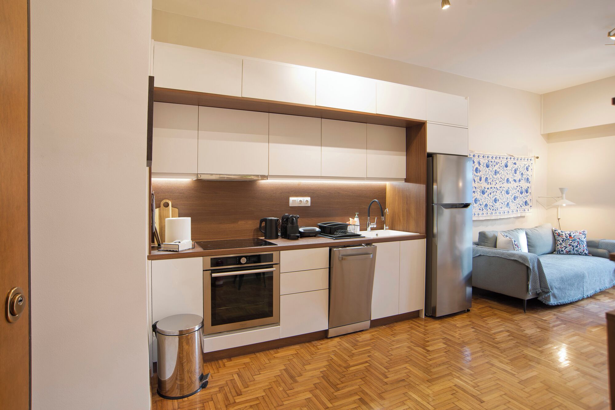 A compact kitchen with modern appliances, a small oven, and a dishwasher.