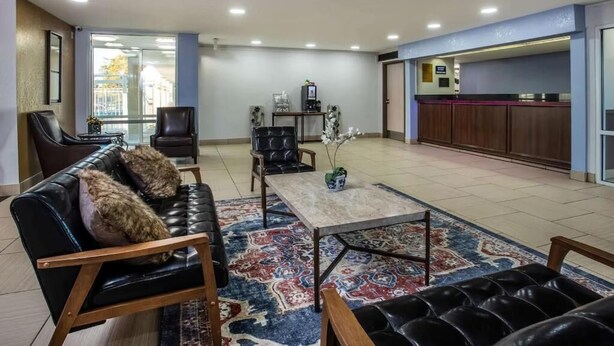 Eine geräumige Lobby mit Ledersofas, einer Kaffeemaschine und einer Rezeption.