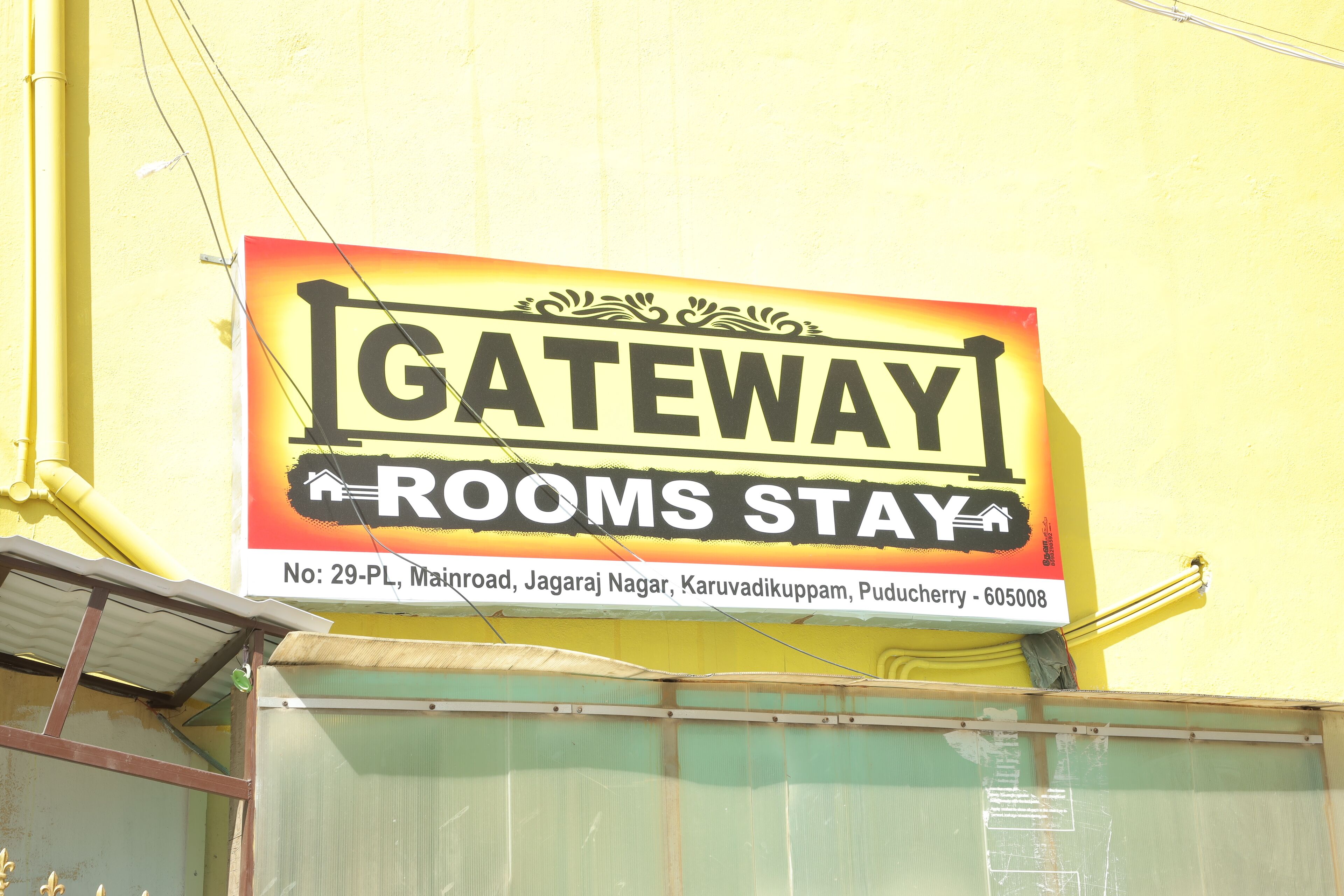 Une enseigne indiquant « GATEWAY ROOMS STAY », avec un numéro de téléphone et une adresse.