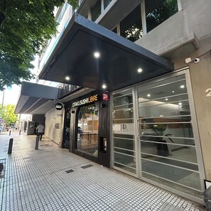 Um edifício moderno com um restaurante de sushi chamado "OTAKUSUSHI LIBRE" no andar térreo.