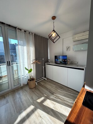 A modern kitchen with a built-in oven, a television, and a hanging light fixture. - RentMontañeses Pileta cerca del Estadio Monumental (Buenos Aires)