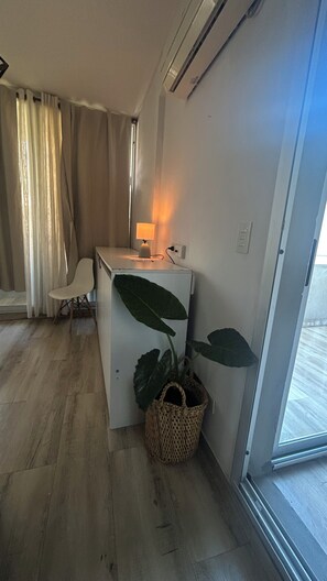Ein kompakter Wohnbereich mit Küchenzeile, Essplatz und großem Fenster.