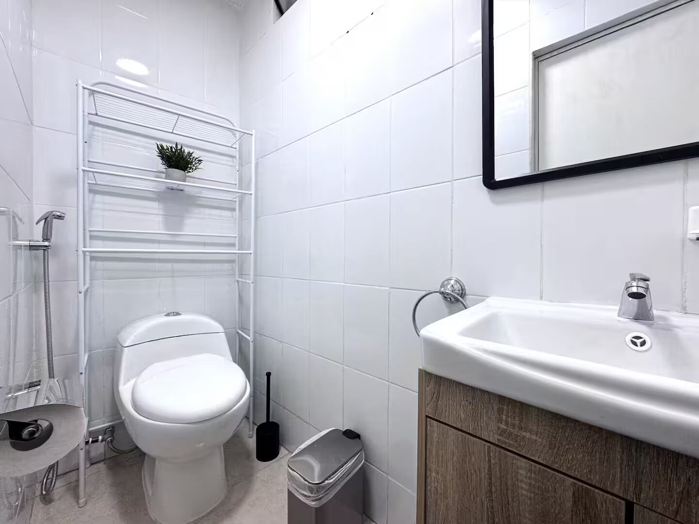 Une salle de bain moderne équipée de toilettes, d’une douche et d’un lavabo.