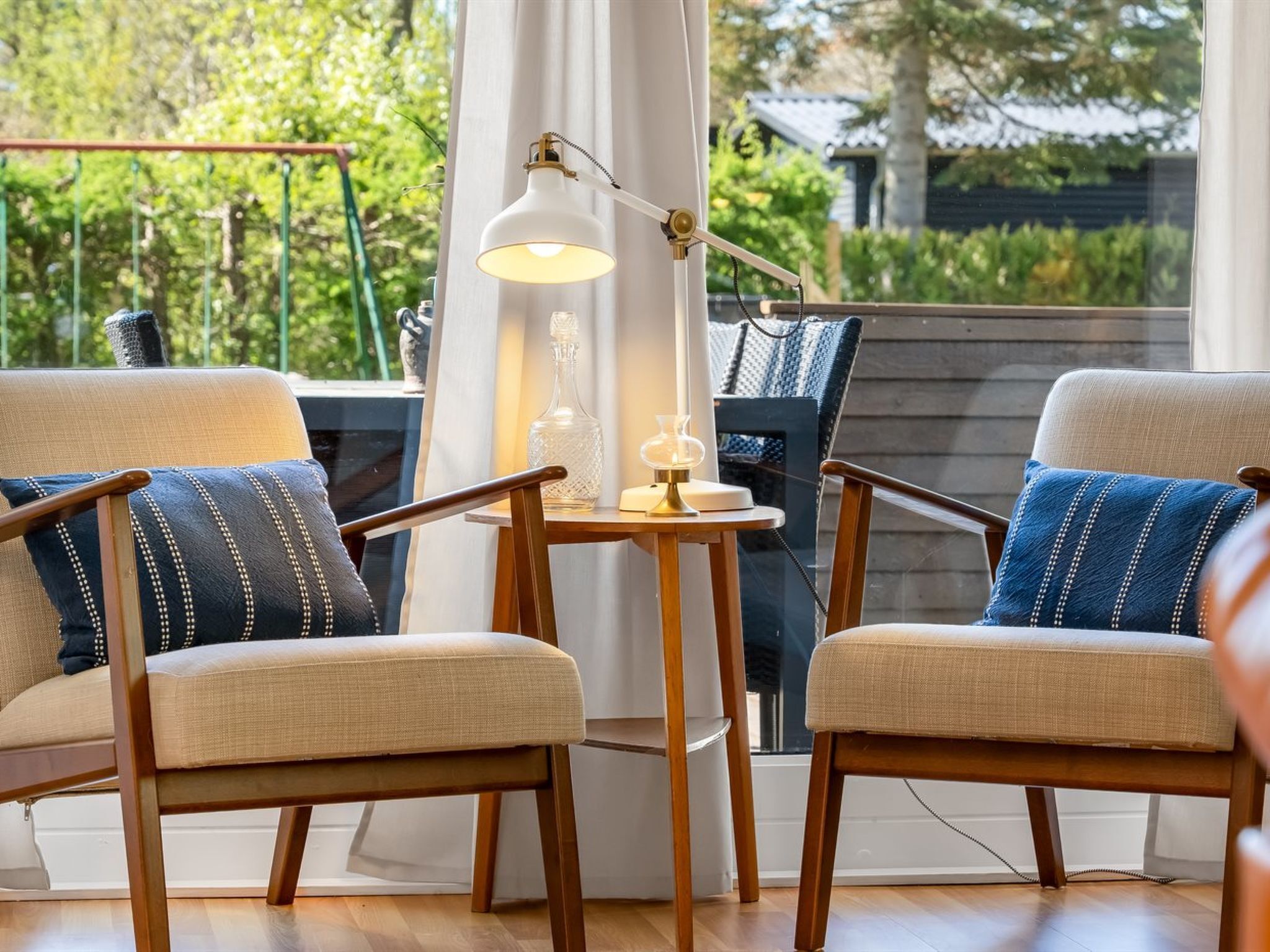 Une pièce avec deux chaises, une petite table et une lampe.