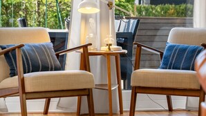 A room with two chairs, a small table, and a lamp.