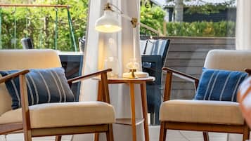Une pièce avec deux chaises, une petite table et une lampe.