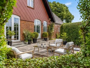 A brick house with a red roof, a patio with outdoor furniture, and potted plants. - "Edla" - 5km from the sea by Interhome (Augustenborg)