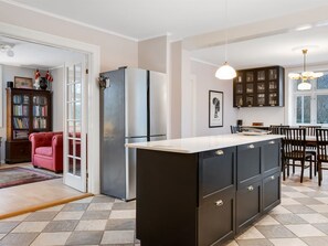 A modern kitchen with a central island, dark cabinetry, and a dining area with a chandelier. - "Edla" - 5km from the sea by Interhome (Augustenborg)