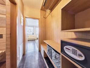 A hallway with wooden walls, a bench, a radiator, and a door leading to a room with a sofa and windows. - Harrachov Resident by Interhome (Harrachov)