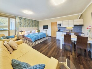 Un apartament modern amb un dormitori, saló i cuina.