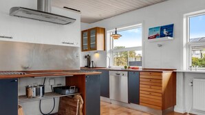 A modern kitchen with a wooden countertop, built-in appliances, and a window providing natural light. - "Talida" - 500m from the sea by Interhome (Skagen)