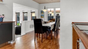 A modern kitchen with wooden flooring, a dining area with a table and chairs, and a view of the outside. - "Talida" - 500m from the sea by Interhome (Skagen)