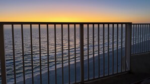 Ein Balkon mit Blick auf den Ozean bei Sonnenuntergang.