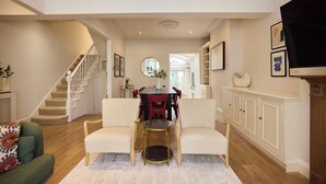 Una sala de estar amplia con una escalera, comedor y chimenea.