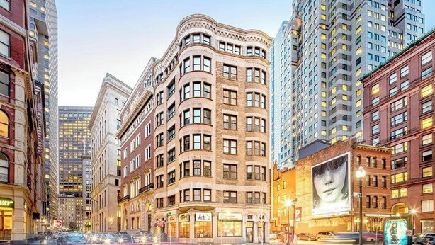 A multi-story building with a classic architectural style, featuring a curved facade and numerous windows. - Walk everywhere - Seaport, North End, Beacon Hill.  Steps from MBTA public transit.  Keyless Entry! (Boston)