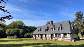 A large, two-story house with a steeply pitched roof, multiple windows, and a well-maintained lawn. - Normandy country house (pool+tennis) 16 pers (Brionne)