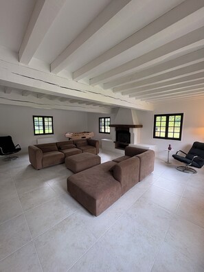 A spacious living room with a sectional sofa, a fireplace, and large windows. - Norman Country House (Pool + Tennis) for 16 People (Brionne)