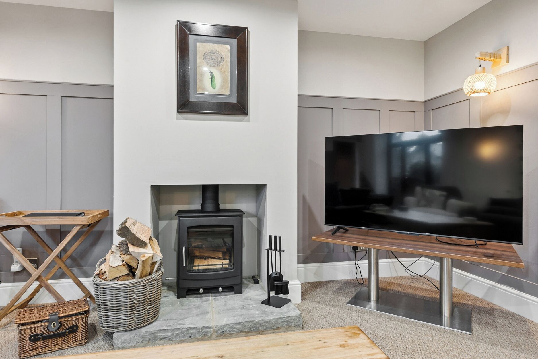 A modern living room with a fireplace, a television, and a framed picture on the wall.