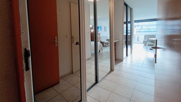 En modern hotellkorridor med glasdörrar som leder till en matsal och en balkong.