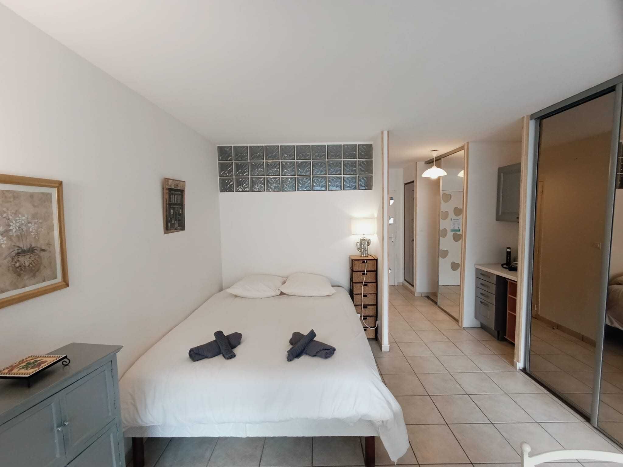 Une chambre à coucher avec un lit, une table de chevet, une lampe et une armoire.