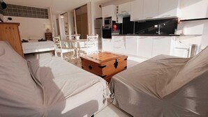 Ett modernt vardagsrum med en soffa, en trälåda och ett matbord.