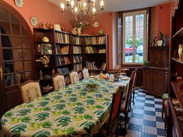 Un comedor con una mesa preparada para cuatro personas, rodeado de estanterías llenas de libros.