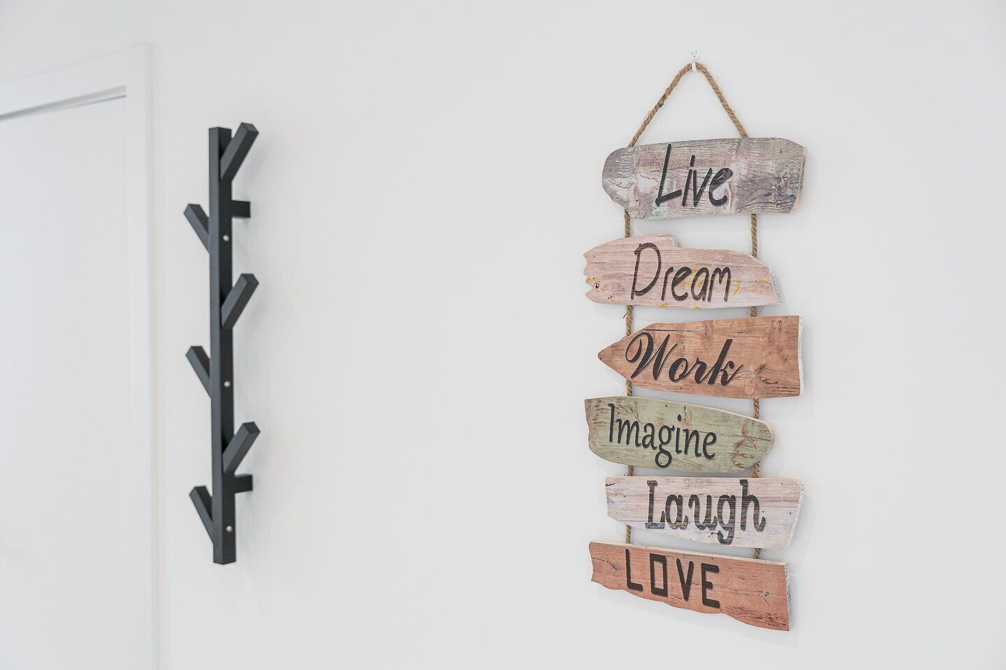 Un letrero de madera atornado a la pared con frases motivacionales.