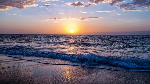 A sunset over the ocean with waves crashing onto the shore. - Ciel de Bora - Panoramic Ocean View & Parking (Saint-Hilaire-de-Riez)
