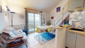 A compact kitchen with a dining area, a small seating area, and a view to the outside. - Ciel de Bora - Panoramic Ocean View & Parking (Saint-Hilaire-de-Riez)