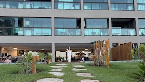 Un edificio moderno con varios pisos, grandes ventanales y un patio central con un sendero.