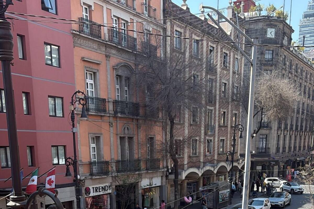 Une vue de rue avec des voitures, des piétons et des bâtiments.