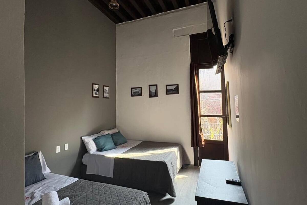 Une chambre avec deux lits, un bureau et une fenêtre.