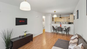A modern apartment with a living room, dining area, and kitchen. - Stylish 1-Bed Flat in London’s Prime Diamond District (London)
