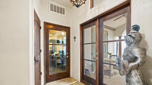 A hallway with a wooden door, a glass door, and a metal sculpture. - ☀️Private pool | Luxury | Golf Cart | 6 Bikes | Villa Tranquility☀️ (Destin)