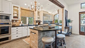 A modern kitchen with a central island, built-in appliances, and a chandelier. - ☀️Private pool | Luxury | Golf Cart | 6 Bikes | Villa Tranquility☀️ (Destin)