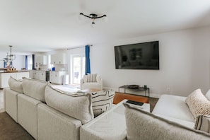 Ein modernes Wohnzimmer mit einer Couch, einem Couchtisch und einem an der Wand montierten Fernseher.