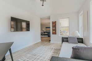 Een moderne hotelkamer met een groot bed, een bureau en een aan de muur bevestigde televisie.