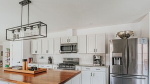 Una cocina moderna con armarios blancos, electrodomésticos de acero inoxidable y una isla de madera.