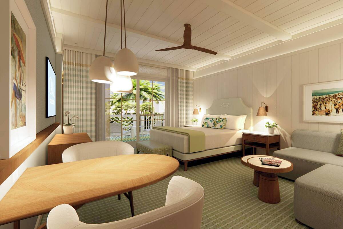 A hotel room with a bed, a sofa, a dining table, and a ceiling fan.