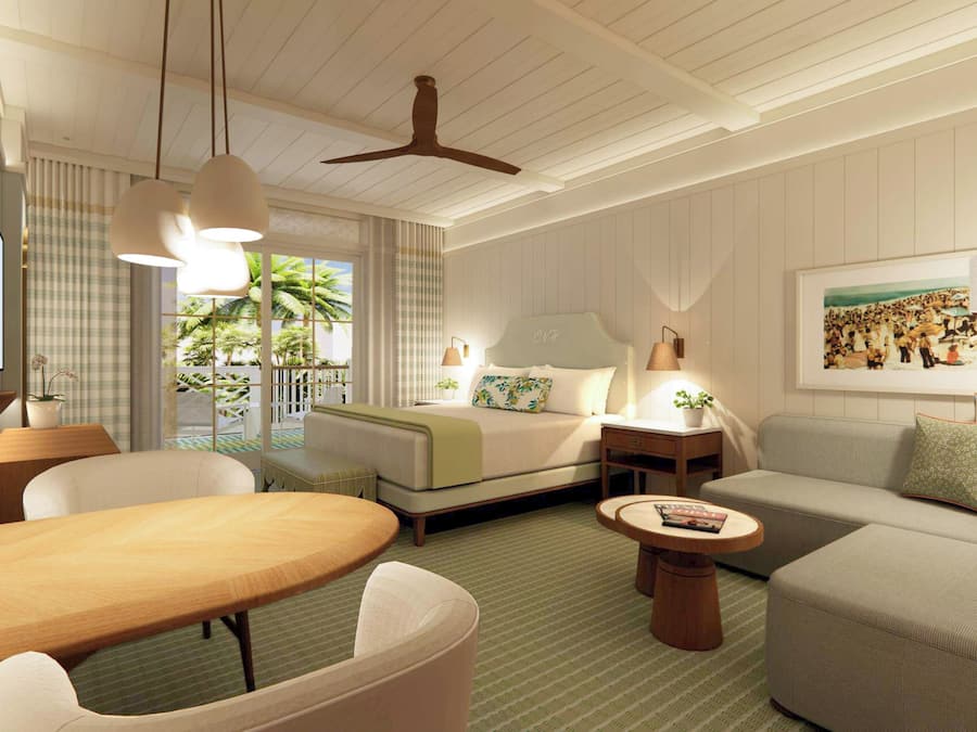 Ein Hotelzimmer mit Bett, Sofa, Esstisch und Deckenventilator.